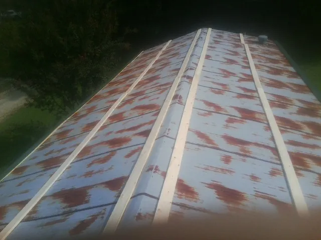 Rusted metal roof panels with new wood purlins before replacement — Storm Damage Roof Repair in Absaraka by Roofing Brothers