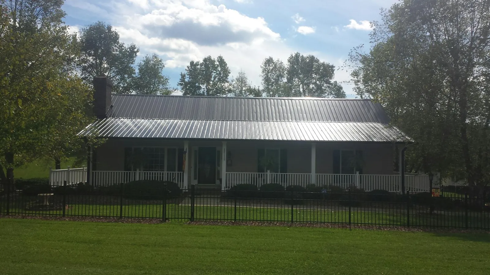 Gray metal roof on a brick ranch with a full width front porch in Absaraka