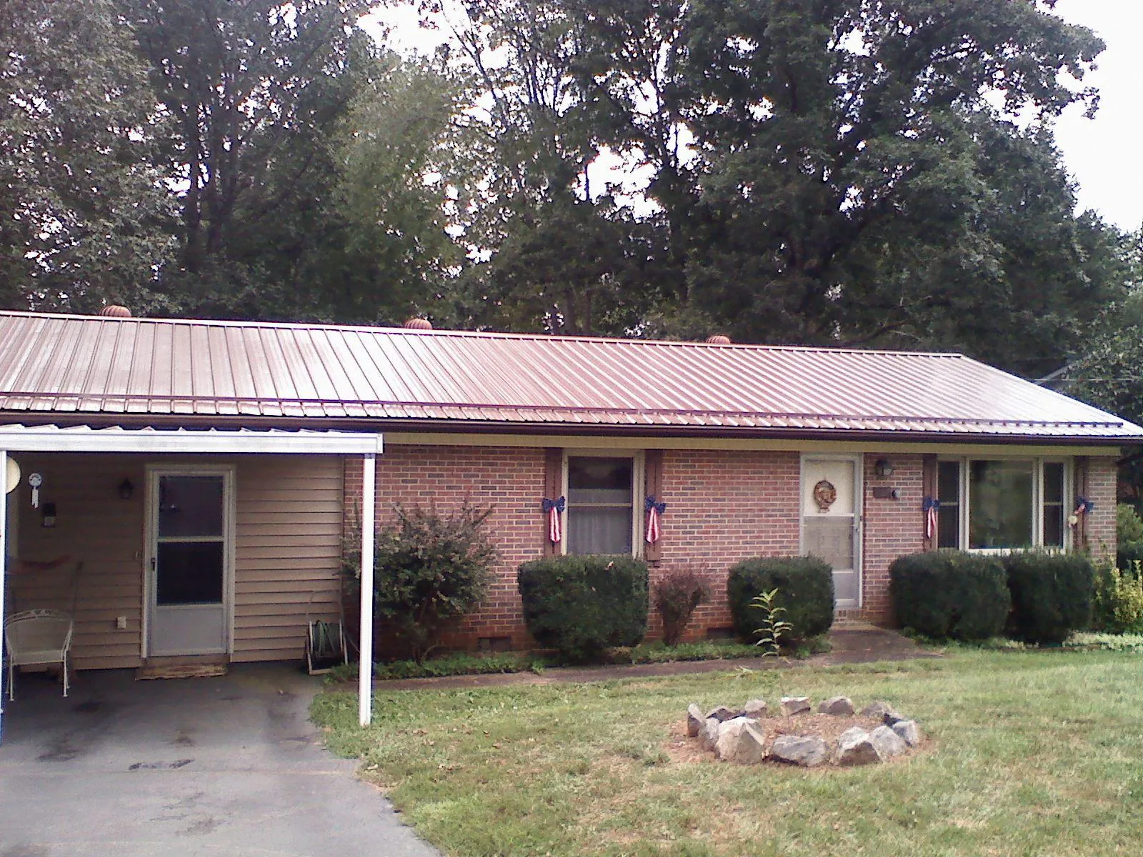 Bronze metal roof and carport on a brick ranch home — Roof Repair work by our crew in Absaraka